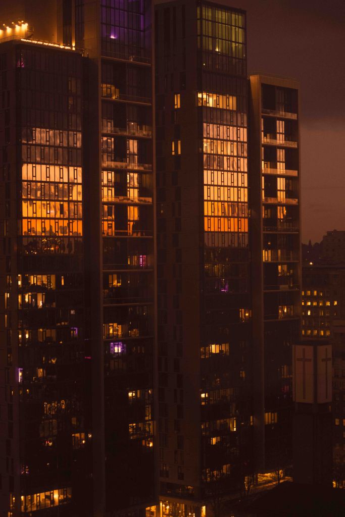 sunrise reflecting off glass building. cast in an orange tint